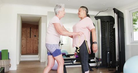 Senior multiracial lesbian couple enjoying fitness routine at home gym