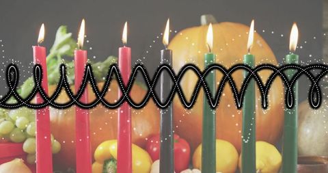 Kwanzaa kinara showing seven lit candles with autumn harvest pumpkin centerpiece