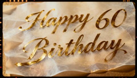 Golden happy 60 birthday lettering on translucent vellum with texture and film border