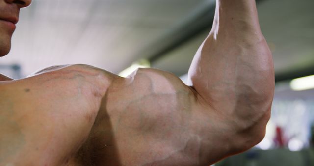 Man flexing biceps in gym