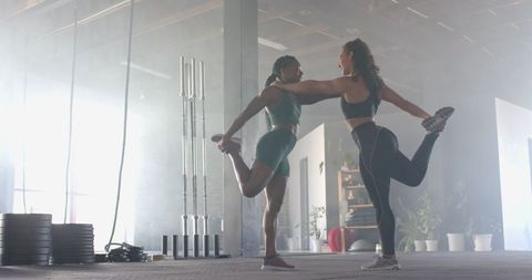 Two Women Stretching in Gym Preparing for Workout