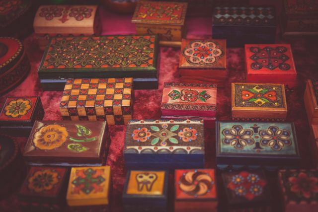 Colorful handcrafted wooden boxes decorated with intricate patterns and floral designs. Useful for articles or blog posts about traditional crafts, artisan markets, cultural heritage, and decorative storage solutions.