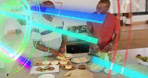 Two men assembling burgers at modern kitchen island with neon holographic overlay