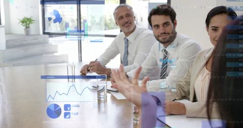 Business Team Analyzing Data on Clear Screen in Office Meeting