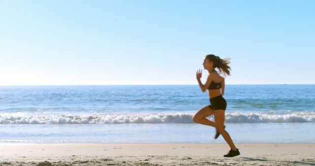 Woman jogging on the beach, with copy space. Outdoor exercise by the sea promotes a healthy lifestyle and relaxation.