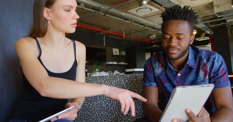 Colleagues Discussing Ideas Using a Tablet in Modern Office