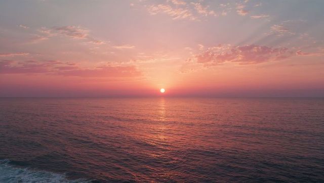 Sunset Over Serene Ocean with Pink and Purple Sky