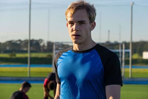 Young soccer player catching breath during outdoor practice