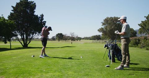 Caucasian Male Golf Players Engaging in Golf on Picturesque Course - Download Free Stock Images Pikwizard.com