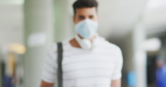 Masked Man With Headphones Around Neck in Indoor Space - Download Free Stock Images Pikwizard.com