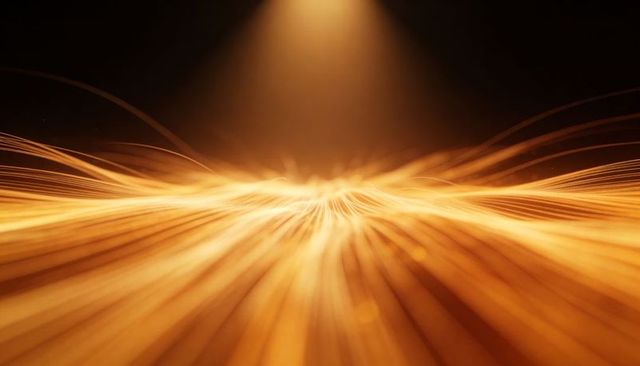 Golden wave of light strands converging to luminous crest with spotlight glow