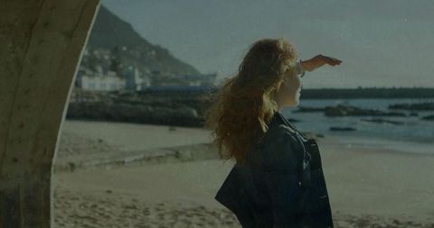Woman on Sandy Beach Beside Concrete Structure During Serene Adventure