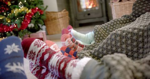 Cozy Family in Wool Socks Relaxing by Fireplace During Christmas