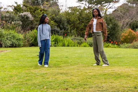 African american teen girls standing on green lawn in park casual fashion and friendship