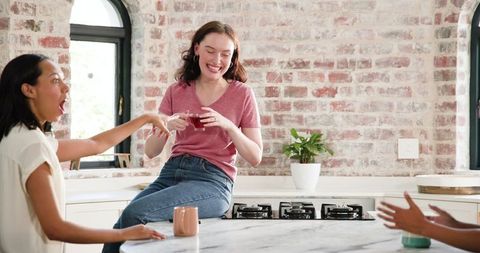 Joyful Female Friends Celebrating Engagement in Cozy Kitchen