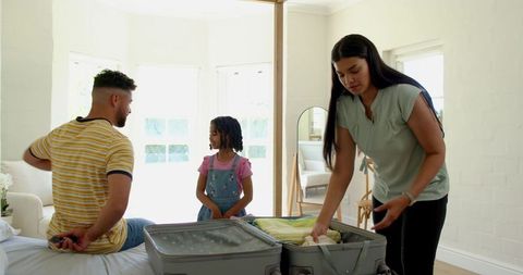 Family Organizing Clothes for a Trip in Elegant Bedroom