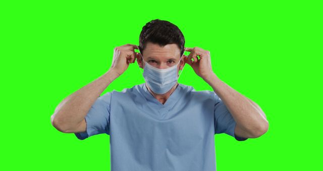 Doctor Putting on Face Mask Isolated on Green Background - Download Free Stock Images Pikwizard.com