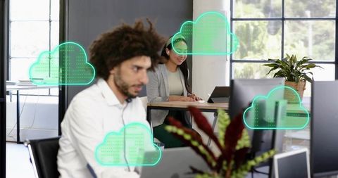 Coworkers working in modern open-plan office with floating cloud network icons