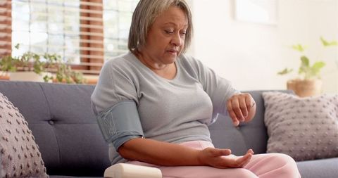 Elderly Woman Monitoring Blood Pressure At Home