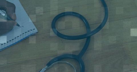 Stethoscope on Wooden Desk with Notebook and Pen