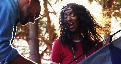 Couple pitching tent outdoors at park