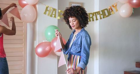 Couple Decorating Home for Birthday Party with Banners and Balloons