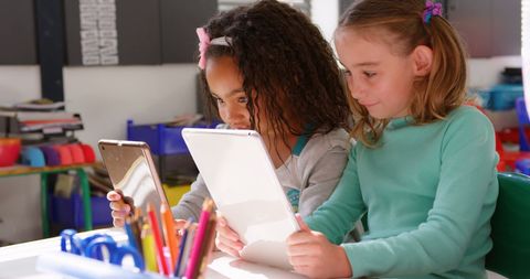 Two Young Schoolgirls Using Tablets Collaboratively - Download Free Stock Images Pikwizard.com