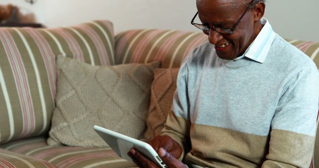 Happy Elderly Man Using Tablet on Couch - Download Free Stock Images Pikwizard.com