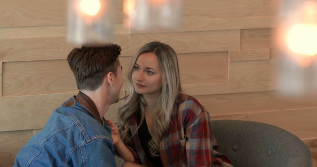 Young couple interacting with each other in cafe. Couple sitting on arm chair in cafe 4k