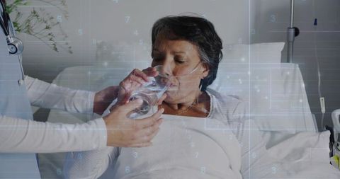 Doctor Assisting Hospital Patient Drinking Water with Nasal Oxygen Tube