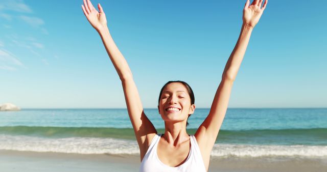 Happy woman standing with arms outstretched on beach 4k