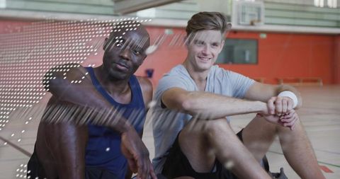 Resting Athletes Taking Break on Basketball Court in Gymnasium