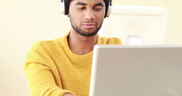 Focused Man Wearing Headphones Working on Laptop at Desk - Download Free Stock Images Pikwizard.com