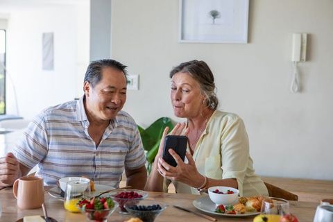 Cheerful Couple Enjoying Video Call During Breakfast at Home