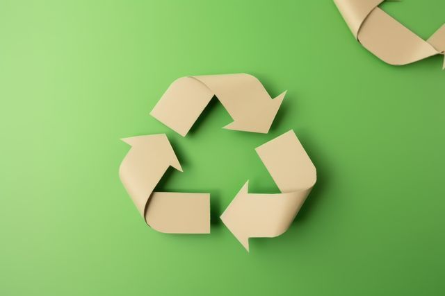 Paper arrows recycling sign on green background, created using generative ai technology. Recycling, environment and climate change awareness concept digitally generated image.