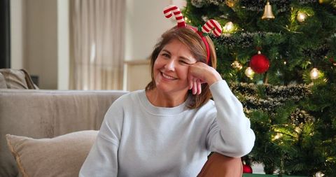 Joyful senior woman celebrating christmas with candy cane headband