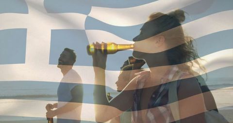 Friends enjoying coastal sunset beverage with greek flag overlay