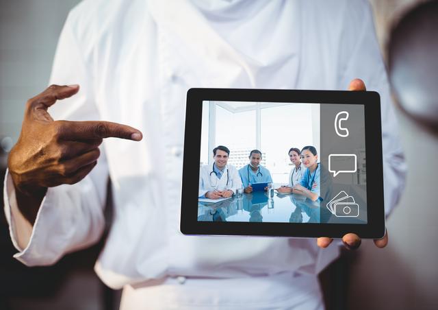 Healthcare professional (hands seen) holding digital tablet displaying video chat with other medical professionals. Represents modern healthcare technology; ideal for promoting telemedicine services, digital health solutions, or telehealth consultations.