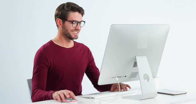 Young Man Working at Computer with Smile in Modern Office - Download Free Stock Images Pikwizard.com