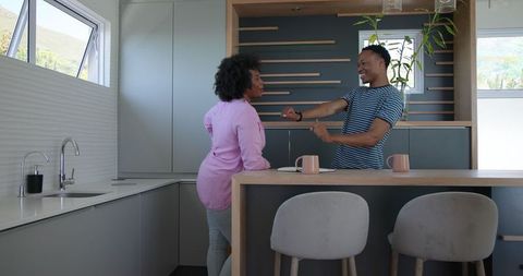 Smiling Couple Writing in Notebook in Modern Kitchen Setting