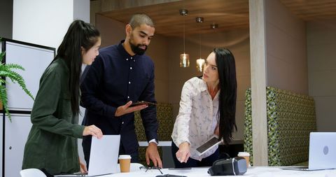 Collaborative Office Meeting with Diverse Team Members Discussing Ideas