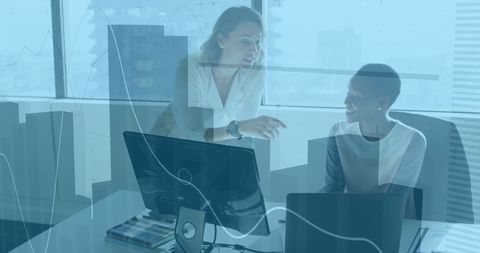 Two Businesswomen Collaborate on Project in Modern Office