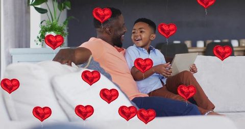 Father and Son Bonding on Couch with Heart Balloons