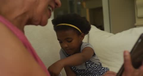 African American Grandmother and Granddaughter Using Tablet