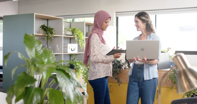 Two Women Collaborating with Laptop and Tablet in Modern Office - Download Free Stock Images Pikwizard.com