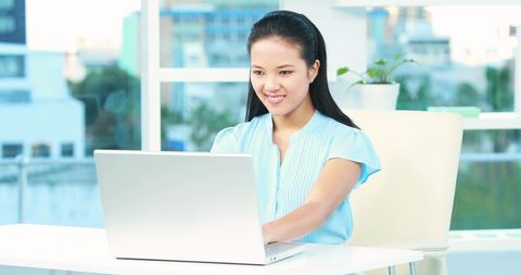 Smiling Asian Businesswoman Working on Laptop in Office - Download Free Stock Images Pikwizard.com