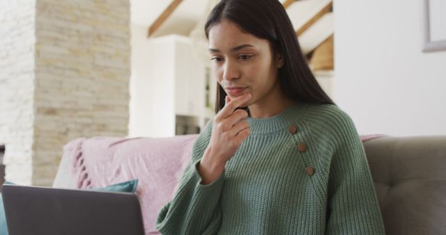 Biracial woman using laptop and working in living room - Download Free Stock Photos Pikwizard.com