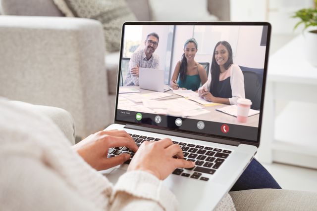 Businesswoman working from home engaging in a video call with smiling multiracial colleagues. Ideal for content about remote work, online meetings, teamwork, and business communication.