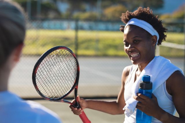 Smiling African American Female Tennis Player Interacting with Teammate - Download Free Stock Photos Pikwizard.com
