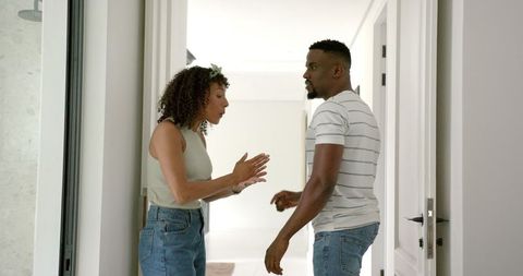 Couple arguing in hallway illustrating domestic disagreement
